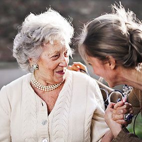 Resilienza psicologica nella non autosufficienza: persona anziana che riceve supporto da un familiare.